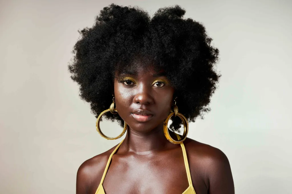 A young black American woman, showing her beautiful afro hairstyle. This represented the freedom to embrace natural curls, after generations of pressure to conform to European beauty standards during the Civil Rights Movement in the United States in the 1960's and 1970's.