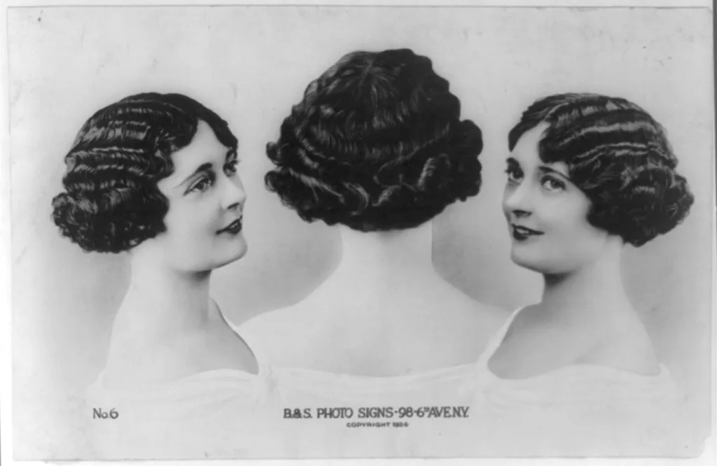 An image from the Library of Congress, a woman in 1924 showing her bob haircut, and introducing textured finger waves, symbolizing the flapper style of the roaring twenties in American history, during the prohibition era that spawned the speakeasy and jazz music in the early 20th century. These techniques are still popular at salons and hair studios today!