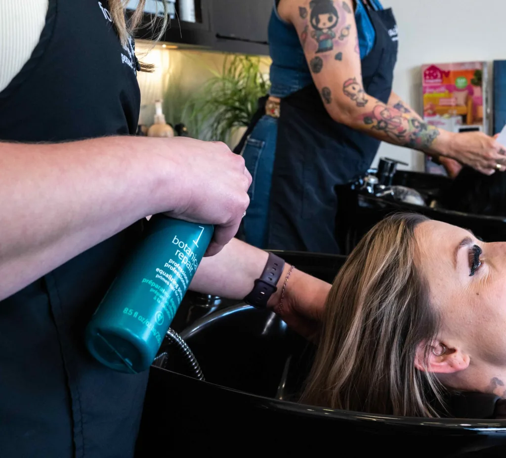 A woman at Panache Hair Salon in Meridian, Idaho, receiving an Aveda botanical repair scalp treatment to help hydrate and moisturize her hair and scalp. 